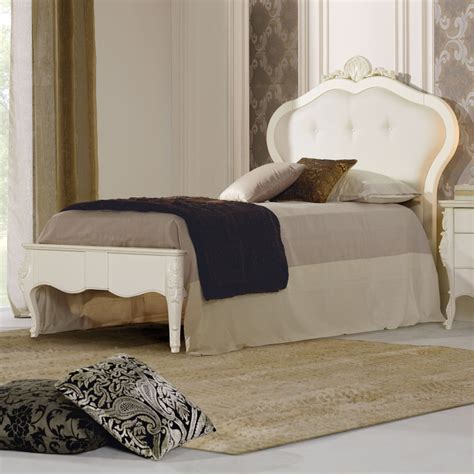 Letto singolo con sponda laterale imbottita antigua, un letto per cameretta con protezione e sostegno ai lati. Letto singolo in legno con testata imbottita
