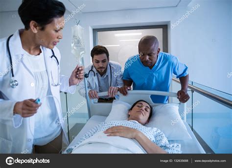 Doctors Adjusting Iv Drip While Patient Lying Stock Photo By