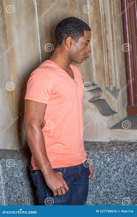 Young Black Man Standing Inside Office Building Looking Around Stock