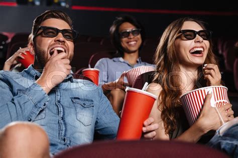 Image Of Laughing Friends Sitting In Cinema Watch Film Eating Popcorn