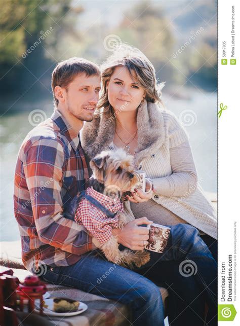 Young Future Parents And Their Dog In A Funny Costume Sitting On A