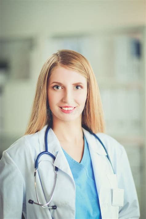 Portrait Of Woman Doctor With Folder At Hospital Corridor Stock Photo