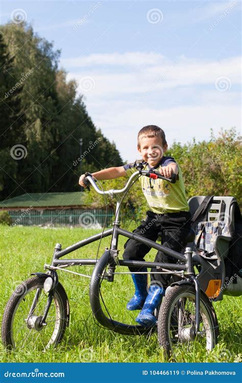 Portrait Of A Little Boy Riding A Tricycle In The Park Stock Image
