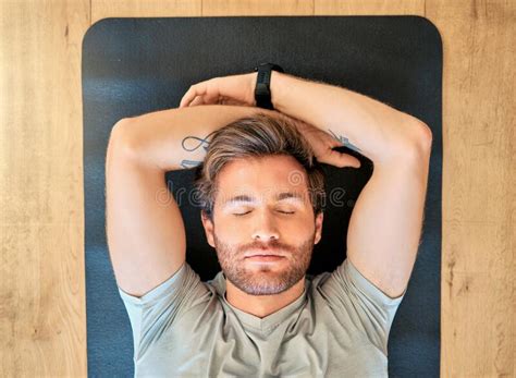 One Fit Young Man From Above Relaxing With Eyes Closed In Meditation While Lying On A Yoga Mat