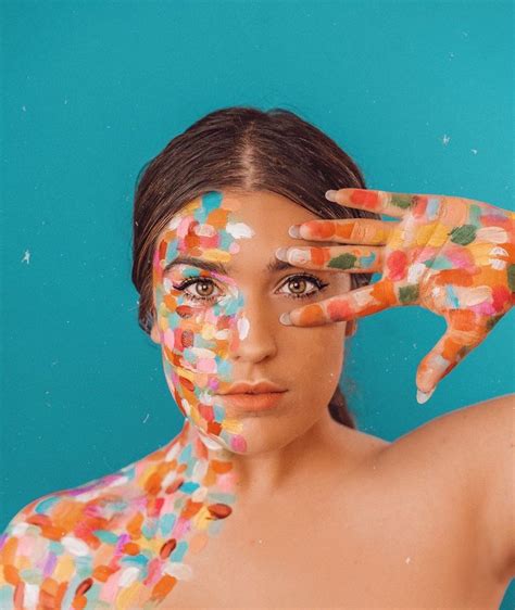 a woman with her hands on her face covered in colored confetti against a blue background