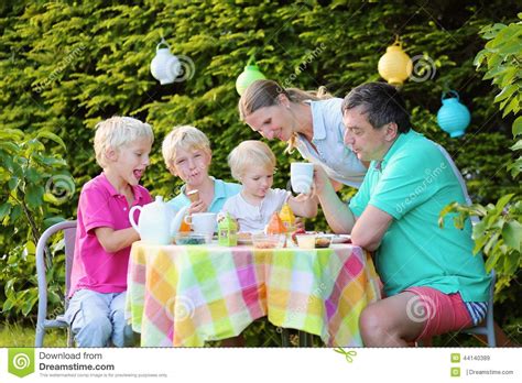 Parents With Kids Having Lunch Outdoors Stock Photo