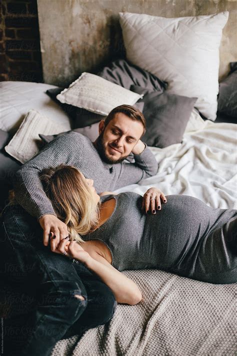 Happy Pregnant Couple Posing On Bed By Stocksy Contributor Andrey Pavlov Pregnant Couple