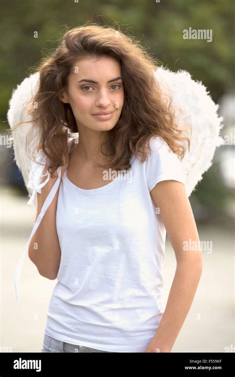 Portrait Of Smiling Woman Wearing Angel Wings Outdoors Stock Photo Alamy