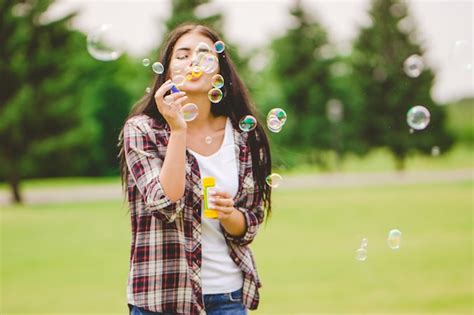 Premium Photo The Woman Blows Bubbles On The Nature