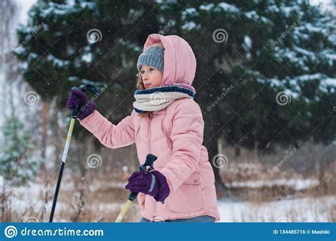 Happy Child Girl Skiing In Winter Snowy Forest Spending Holidays
