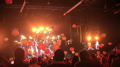 Crowd Of People Having Fun At A Concert With Balloons Flying Around The