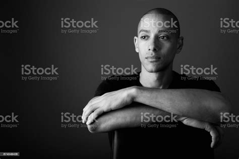 Studio Shot Of Mature Handsome Bald Man Against Gray Background In