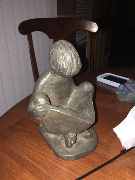 I Have An Austin Prod Sculpture Of A Boy Sitting Holding A Book From Artifact Collectors