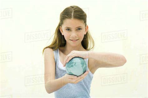 Preteen Girl Holding Small Globe In Hands Smiling At Camera Stock Photo Dissolve