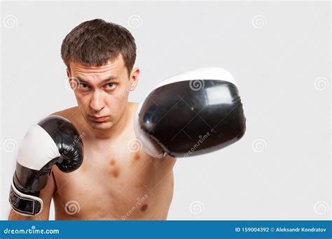 A Man In Boxing Gloves With Bruises On His Body And Face Stabs During A