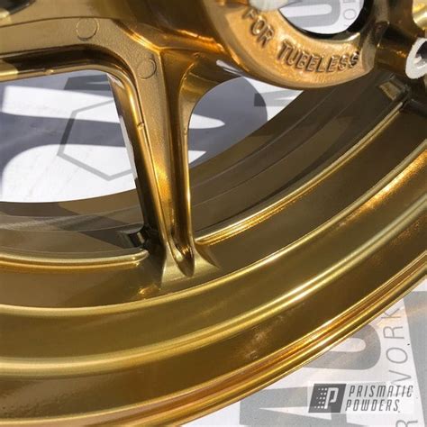 A Close Up Of A Gold Rim On A Vehicle