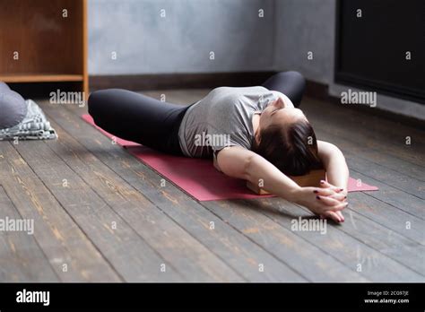 Woman Practicing Yoga In Reclined Butterfly Exercise Supta Baddha