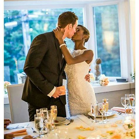 Beautiful Interracial Couple Stealing A Kiss At Their Wedding Reception