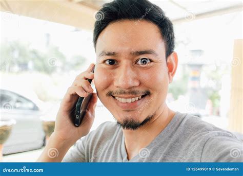 Hombre Feliz Sonriendo Hablando En El Smartphone Imagen De Archivo
