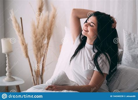 Woman Awakening Stretching In Bed In Early Morning Stock Photo Image
