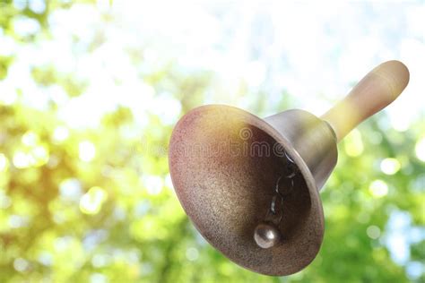 Shiny School Bell With Wooden Handle Outdoors Space For Text Bokeh