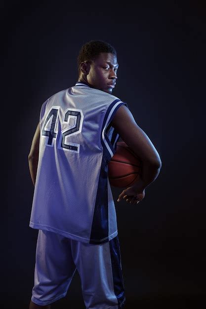 Premium Photo Basketball Player Poses With Ball In Studio Back View
