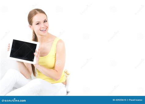 Beautiful Girl Sitting On A Sofa And Shows The Electronic Tablet Stock