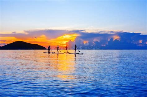 People Silhouettes Stand Sup Paddle Boarding Sea Sunset Beach Active