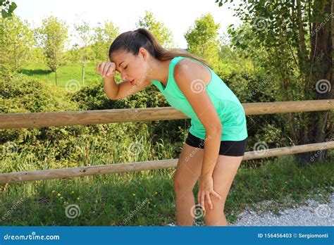 Woman Bent Over In Exhaustion And Catching Her Breath After A Running Session Stock Image
