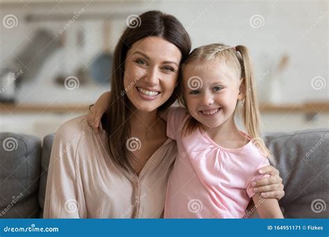 Affectionate Single Mom And Child Daughter Embracing Looking At Camera