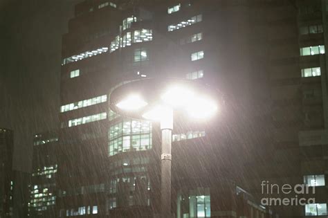 Rain Falling Around Streetlamp At Night Photograph By Caia Image