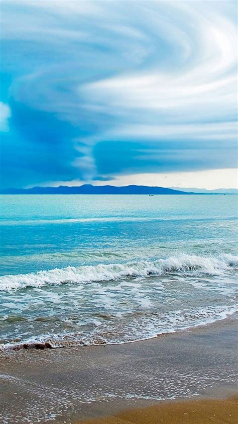 Turquoise Beach Clouds And Distant Mountains Water
