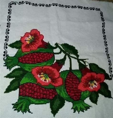 A Close Up Of A Piece Of Cloth With Red Flowers On It And Green Leaves