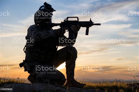 Silhouette Of An Kneeling Soldier Against Sunset Stock Photo - Download ...
