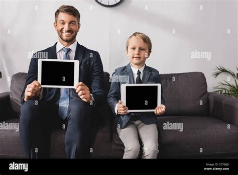 Handsome Businessman And Son In Formal Wear Showing Digital Tablets