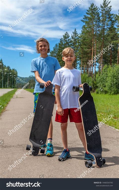 Two Babe Babes Holding Skateboards On The Road