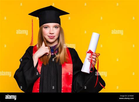 Portrait Girl Graduate With Graduation Hat And Diploma On Yellow