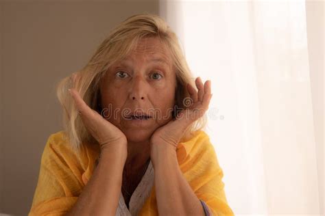 Caucasian Woman In Her 50s To 60s With Blonde Hair And A Surprised