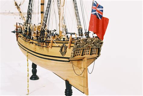 A Wooden Model Ship With A Flag On It