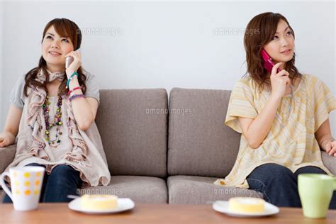 携帯電話で話している女性2人[07800017838]の写真素材・イラスト素材｜アマナイメージズ