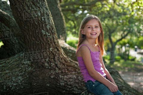Girl Sitting On Tree Stock Photo Dissolve