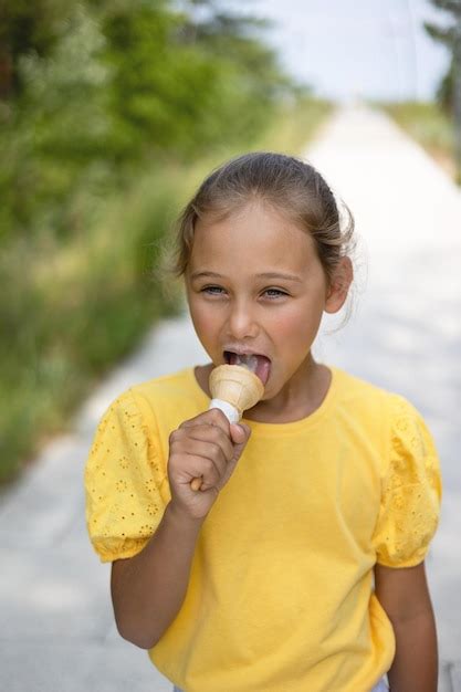 Premium Photo Cute Laughing Child Little Girl Eats Ice Cream On A Hot
