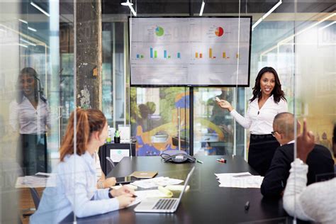 Businesswoman Giving Presentation During Meeting In Office Stock