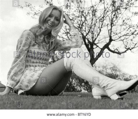 A Woman Sitting On The Grass With Her Legs Crossed