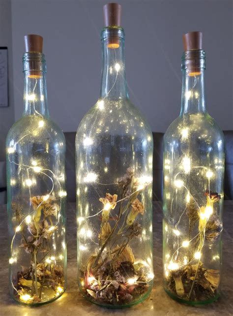 Wine bottles are a great source of glass for crafting. Lights and dried flowers in wine bottles. #diy #upcycling ...