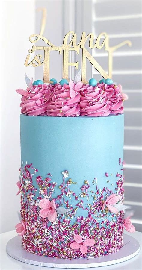 There Is A Blue And Pink Cake With Flowers On It