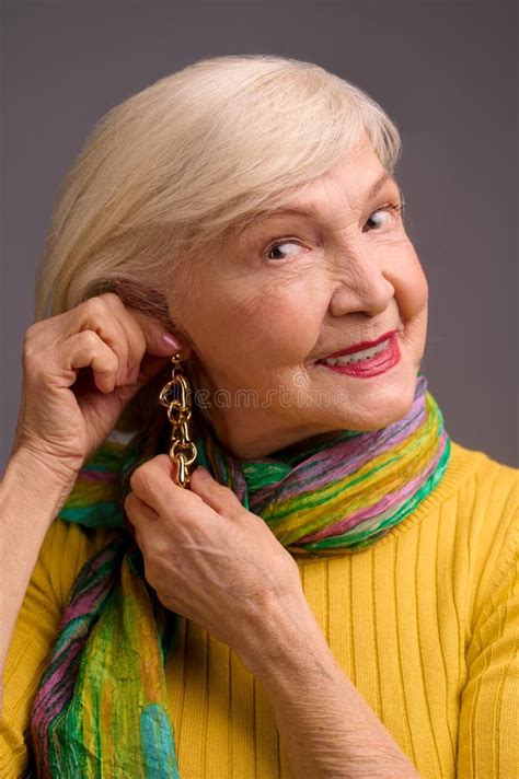 Blone Smiling Senior Woman Putting On Long Earrings Stock Photo Image