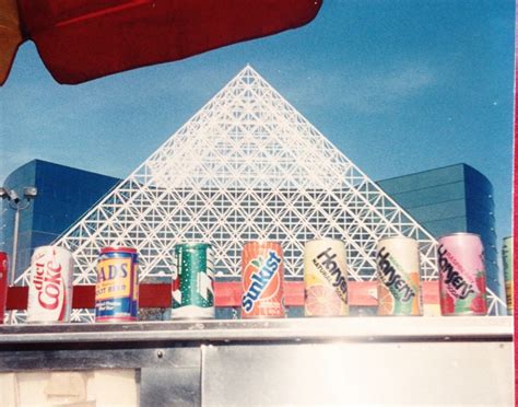 Cans And Cans Are Lined Up In Front Of A Building With A Pyramid On Top