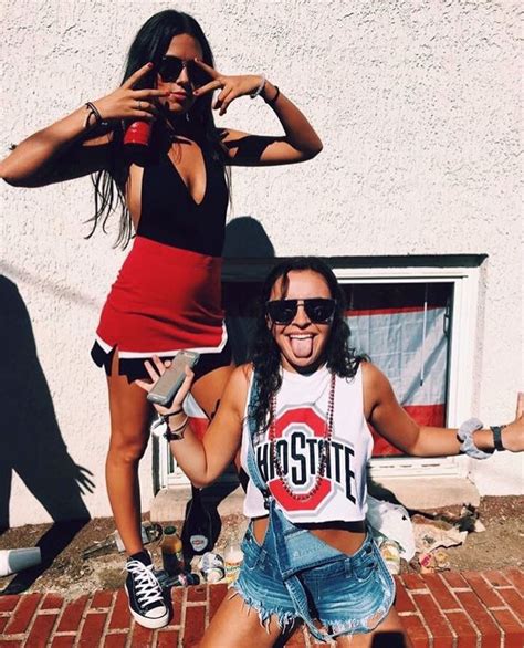 Two Women Sitting On The Ground With Their Hands In The Air And One