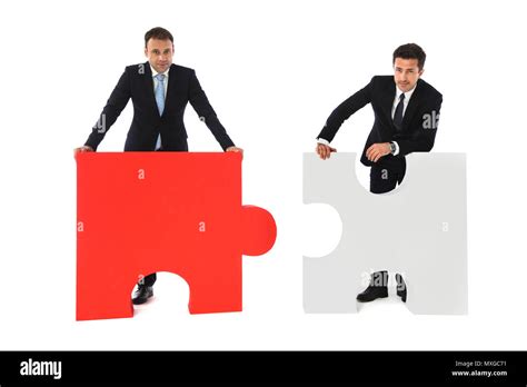 Business Men Holding Two Puzzle Pieces To Connect Isolated On White